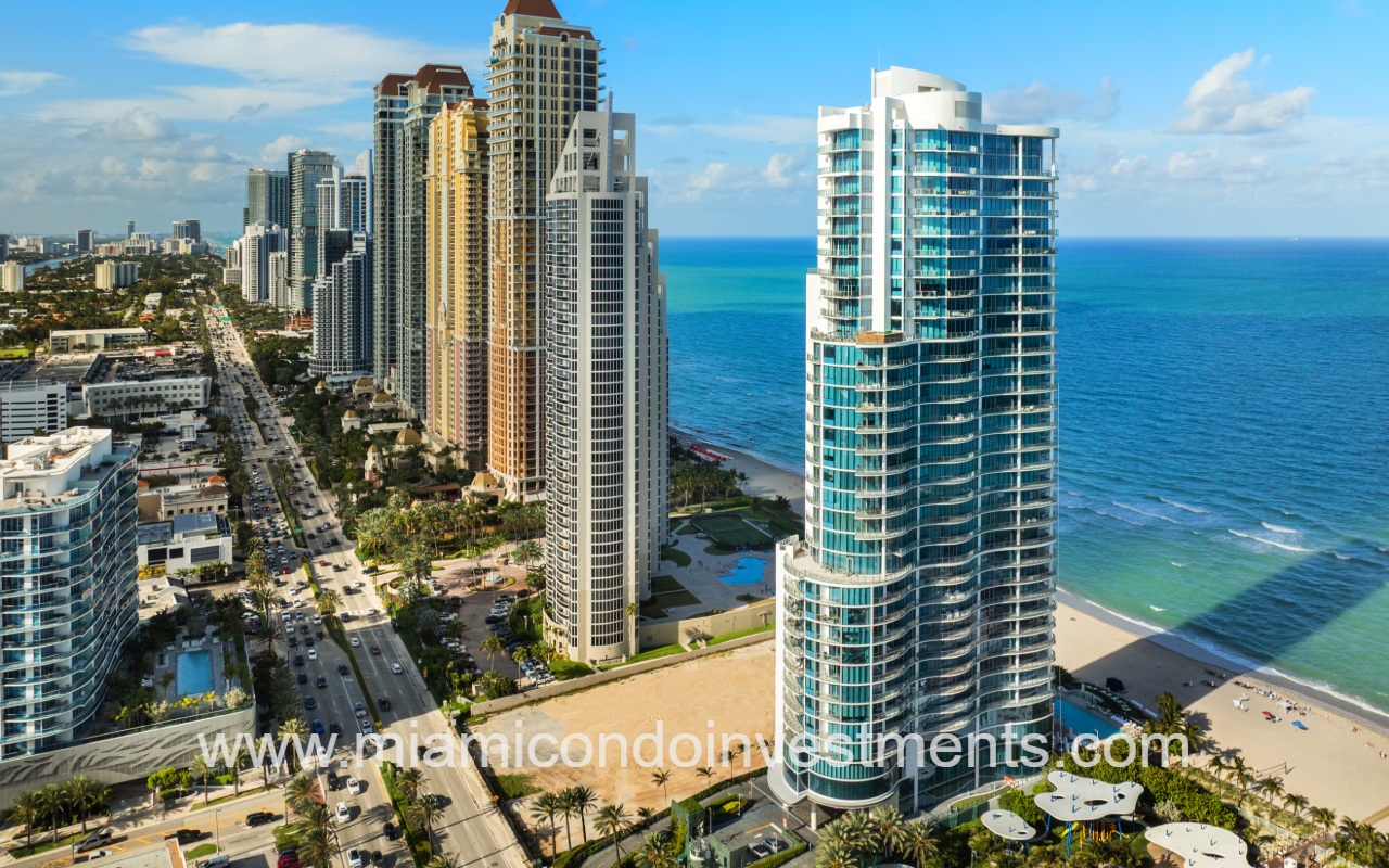 Chateau Beach Residences drone facing northward overlooking condo building with other buildings on blue ocean