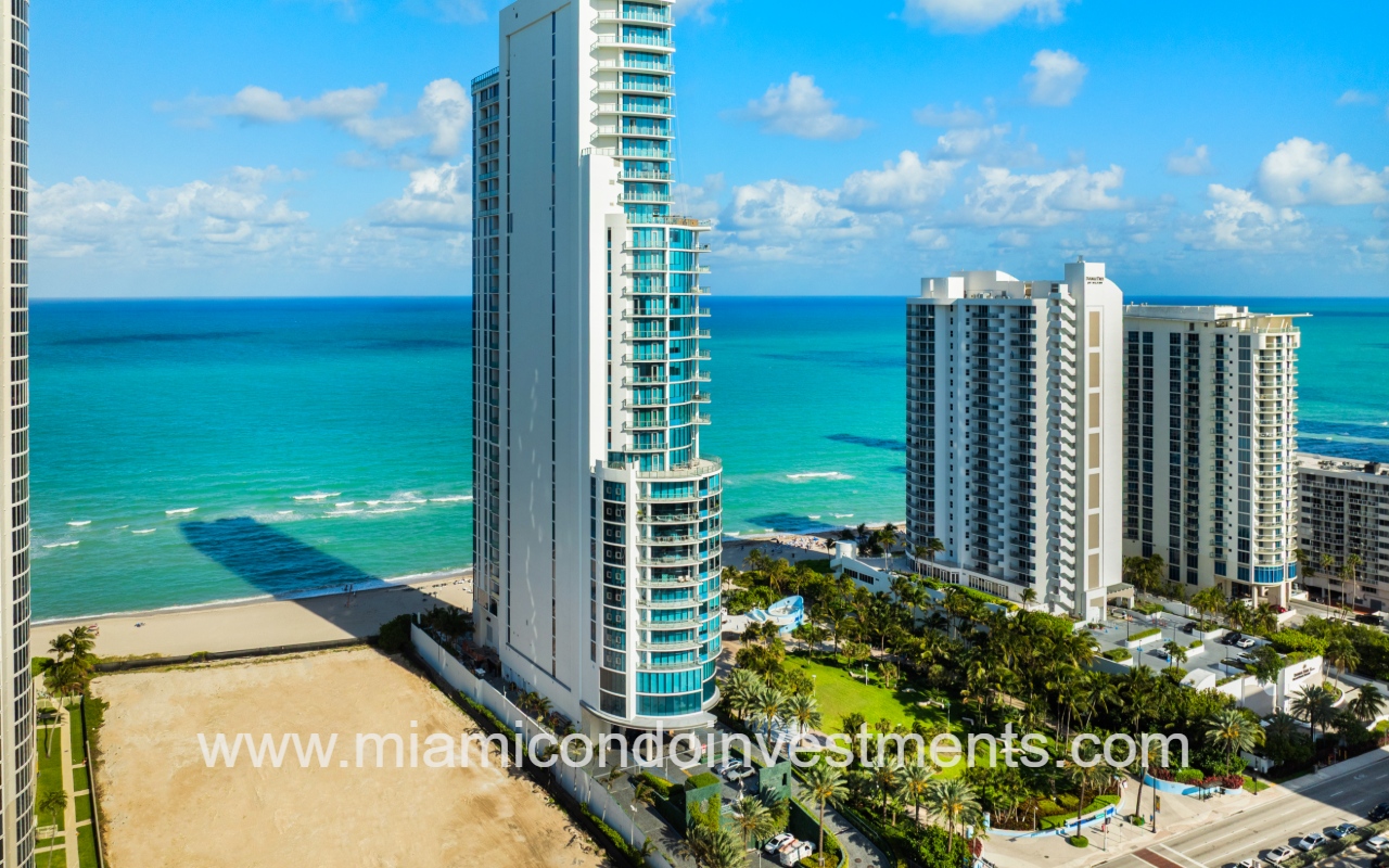 Chateau Beach Residences drone angle facing condo building closeup with blue ocean backdrop