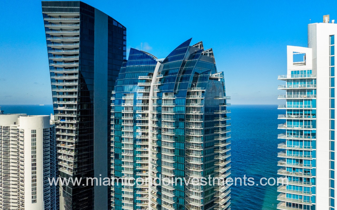 Jade Ocean condos drone angled view of upper half of building and ocean backdrop