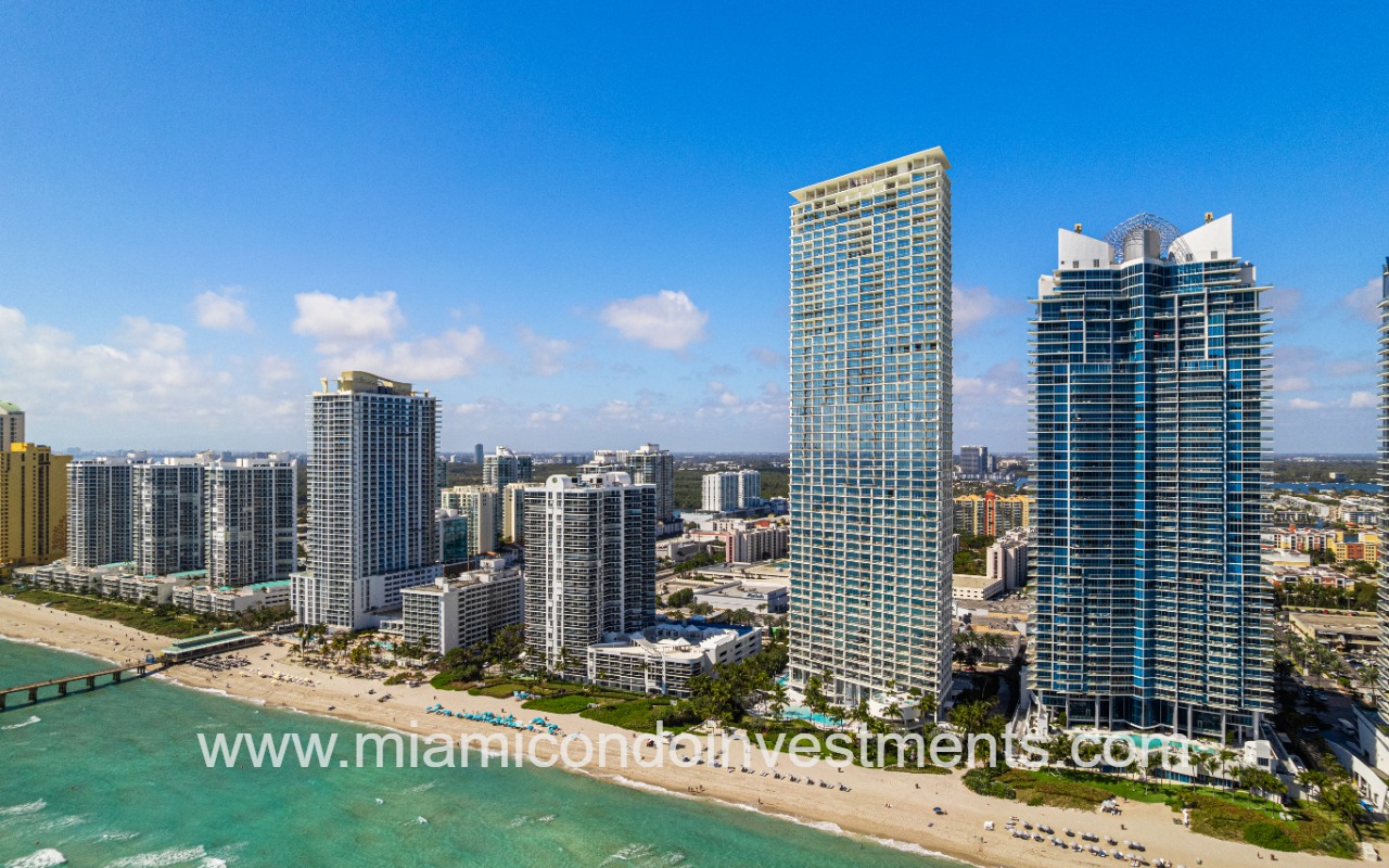 Jade Signature drone facing condo building and beach shoreline