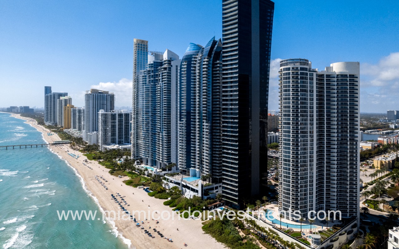 Ocean Four drone of building and beach shoreline long shot