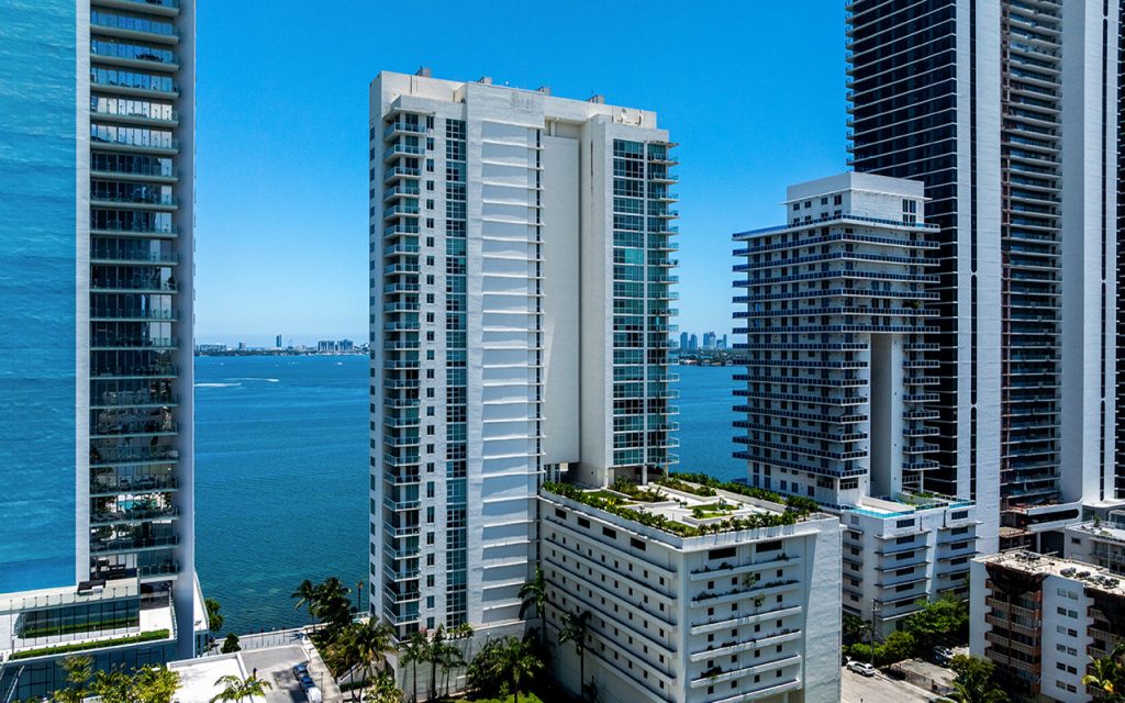 Onyx on the Bay drone view of the front of condo building with bay backdrop