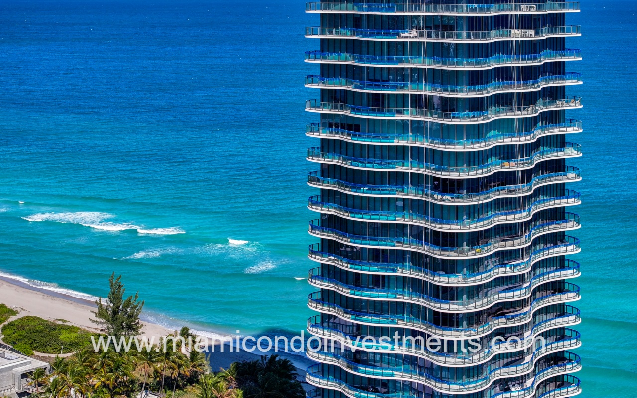 Ragalia drone view facing upper condo building profile exterior with blue ocean backdrop