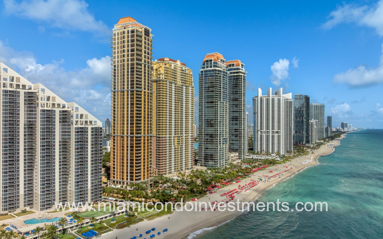 The Mansions at Acqualina drone closeup view facing northward at condo building and buildings along shoreline