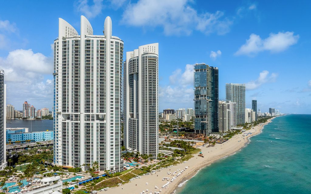 Trump Palace drone facing side angle of building with ocean backdrop