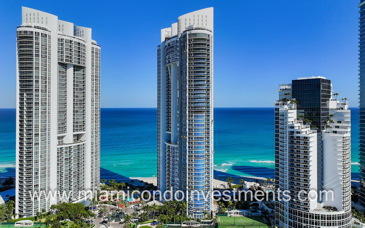 Trump Palace drone facing side of building with blue ocean behind