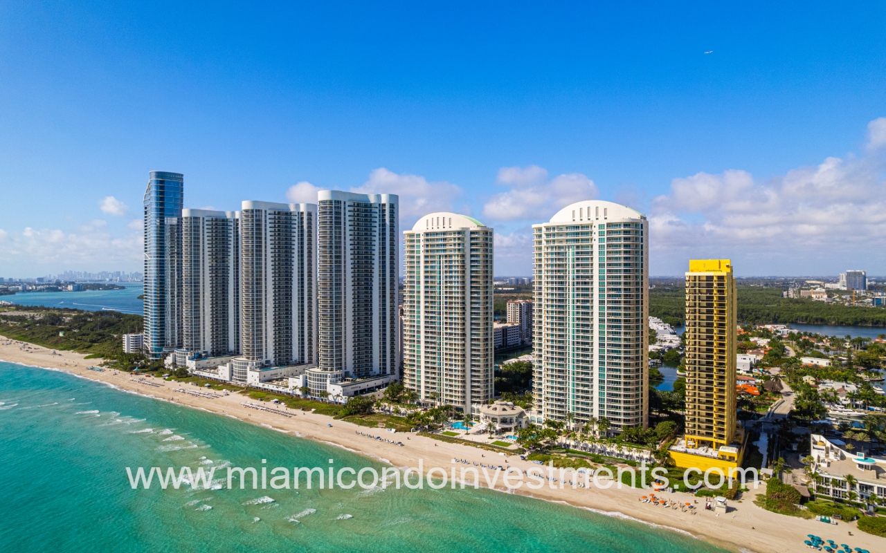 Turnberry Ocean Colony North drone view of condo buildings and other buildings along ocean shoreline