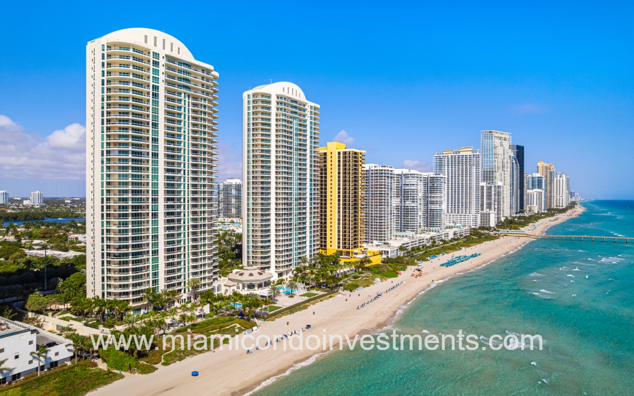 Turnberry Ocean Colony South drone northward facing view with condo building and buildings along ocean shoreline