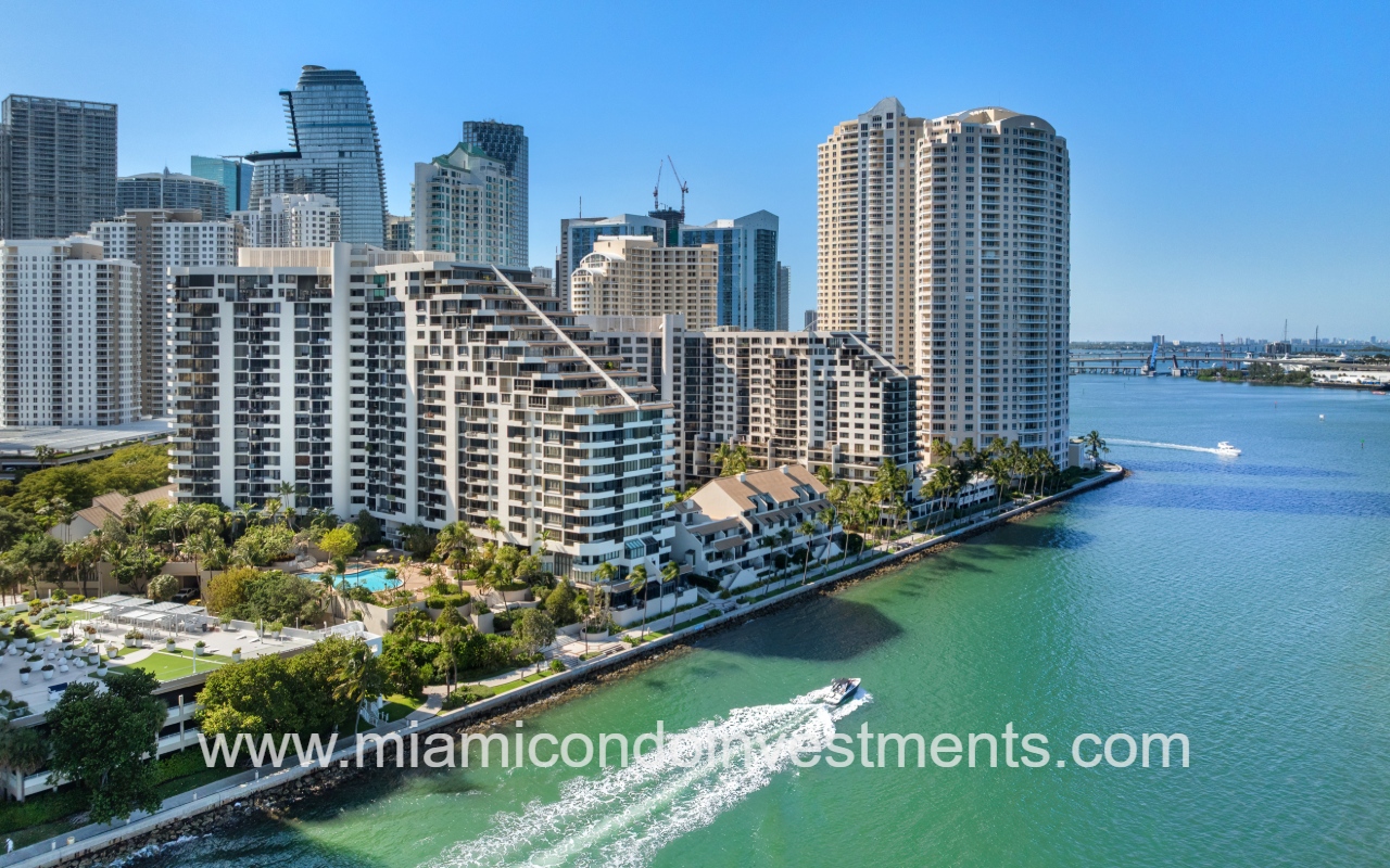Brickell Key One drone view of building slight side angle and boat passing waterway