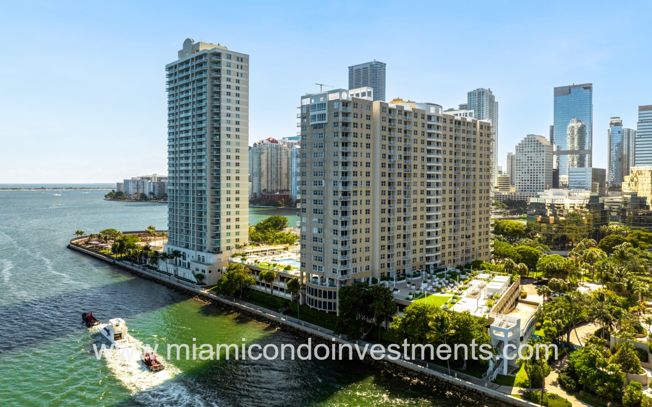 Isola drone view of condo building on waterway with boats passing