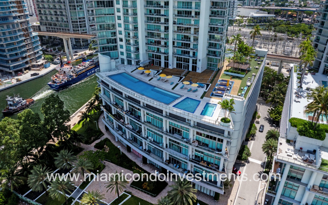 Mint condominium building with drone overlooking lower roof deck pool