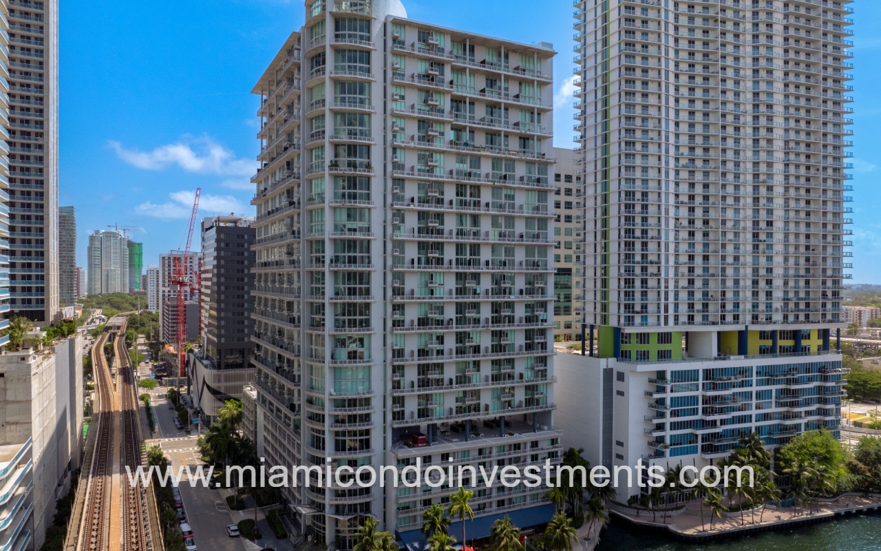 Neo Vertika drone overlooking condominium building on river with view down side street