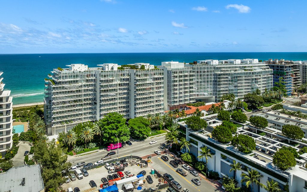 The Surf Club Four Seasons closeup drone angle view of front of condo building with blue ocean backdrop