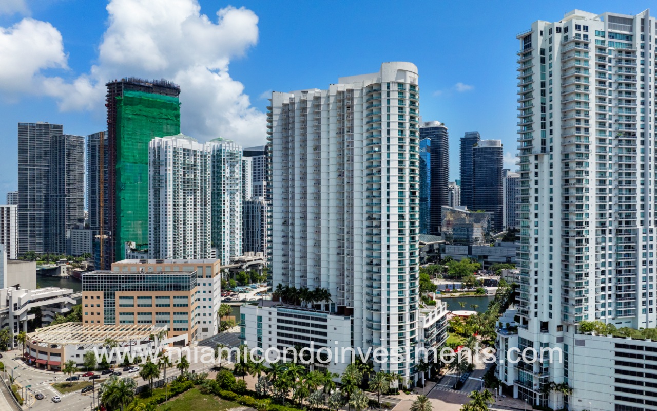 Wind drone of condo building with buildings surrounding