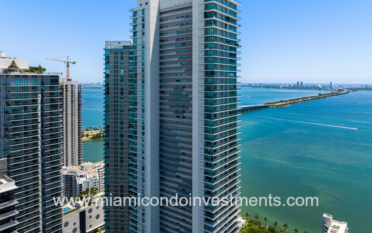 Gran Paraiso drone view top half of condo building exterior with waterway backdrop