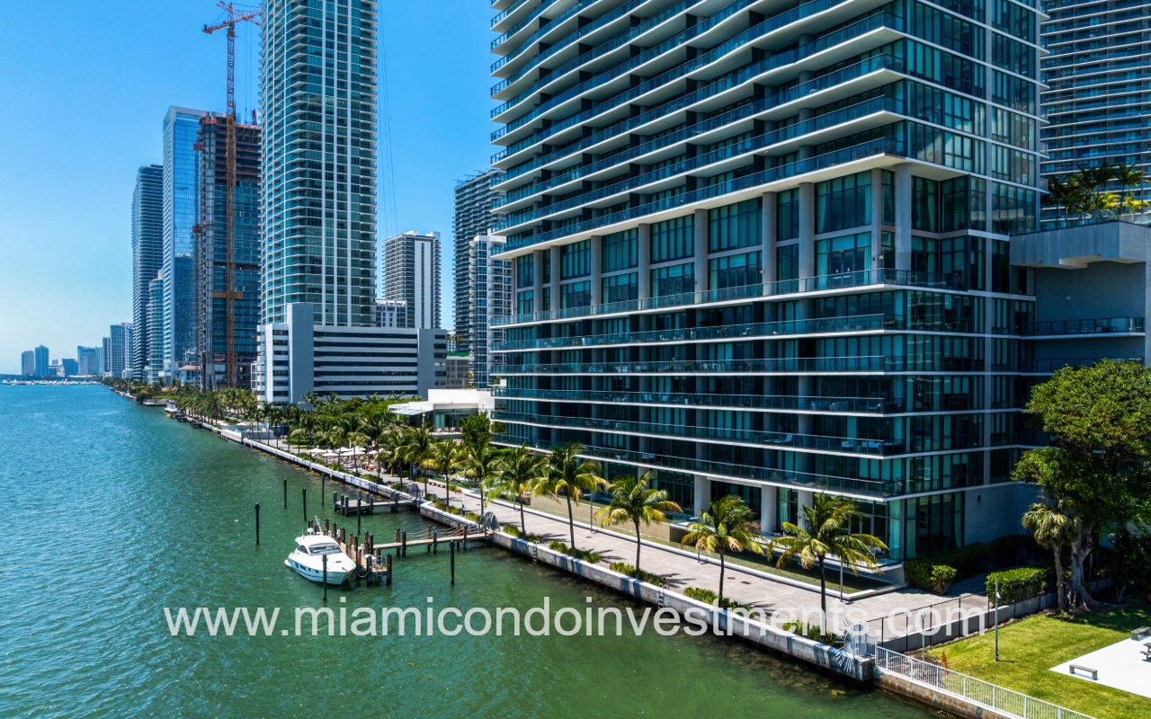 One Paraiso drone lower condo building exterior and boat docked along waterfront