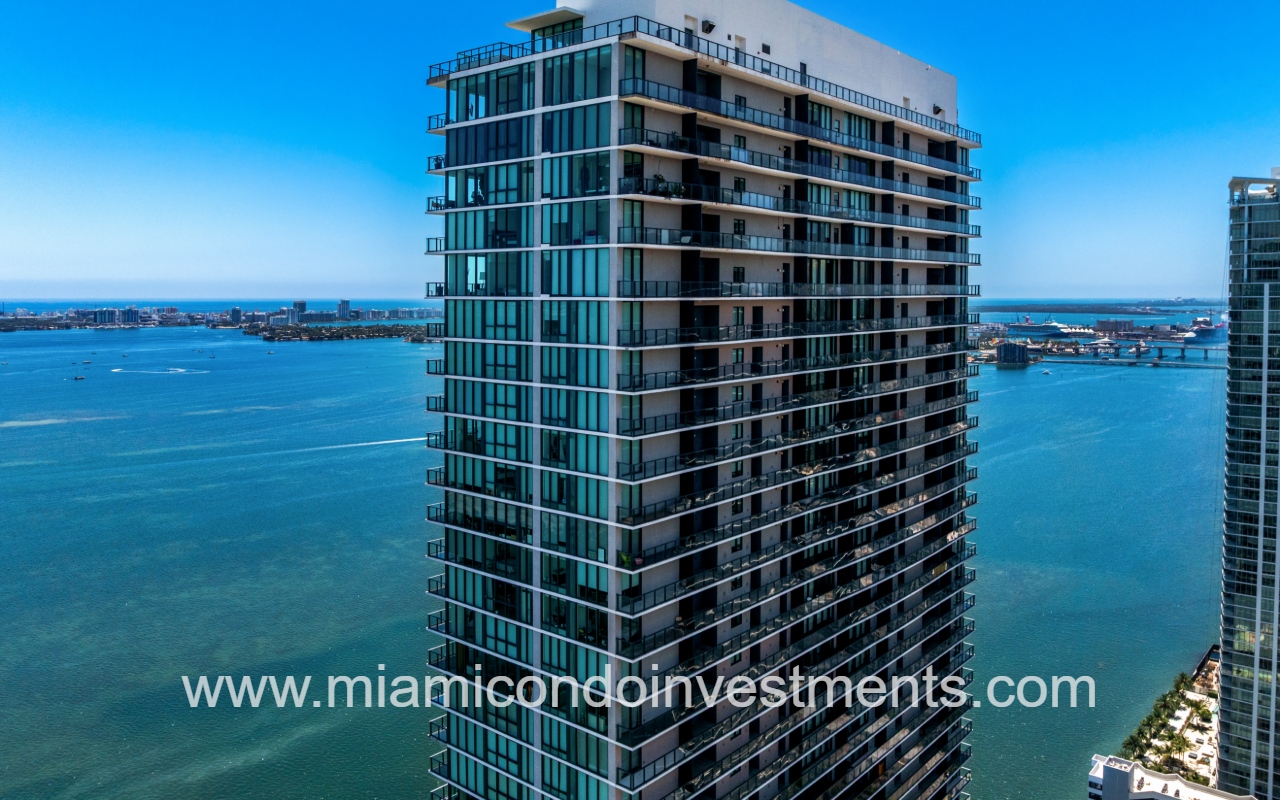 One Paraiso drone view of the top half of condo building exterior with the bay backdrop