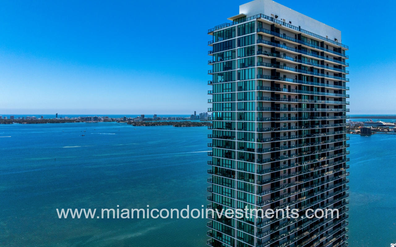 One Paraiso drone view of the top half partial condo building exterior with the bay in background