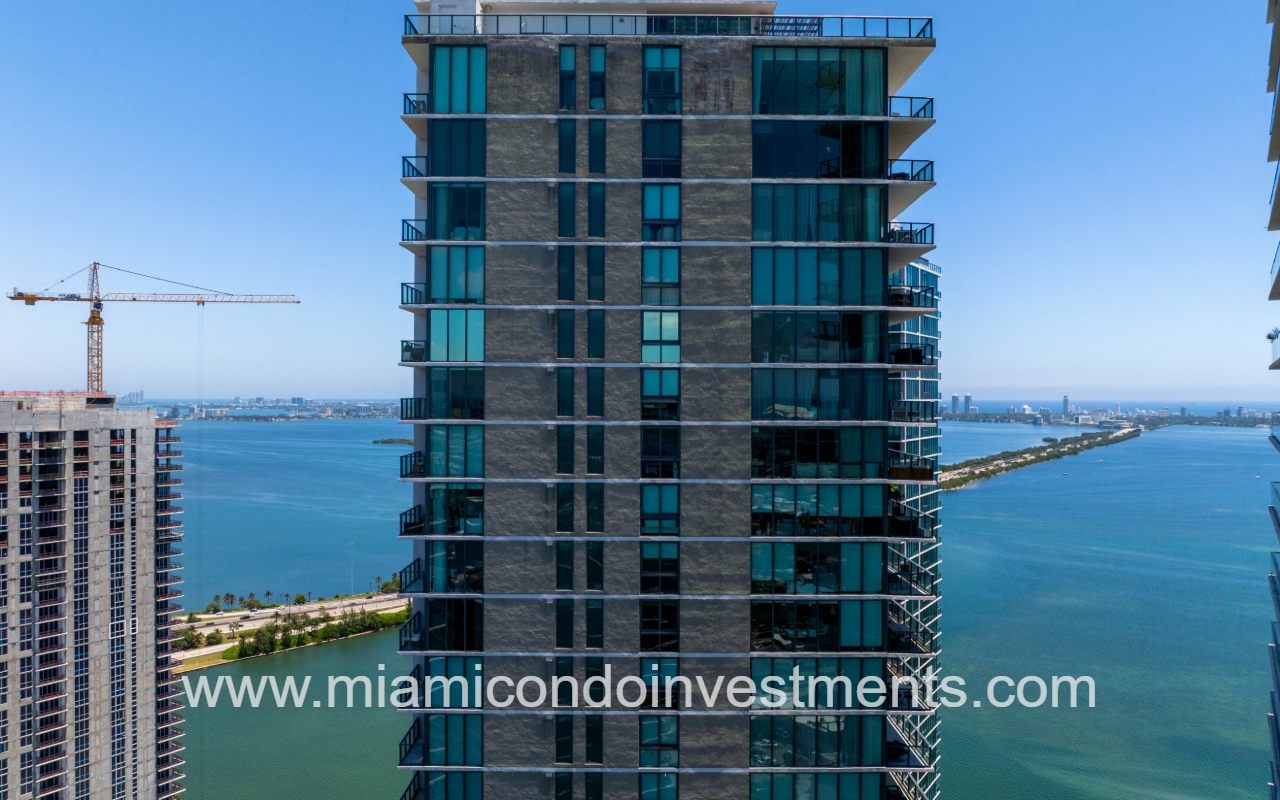 Paraiso Bay drone facing side of condo building exterior with bay view backdrop