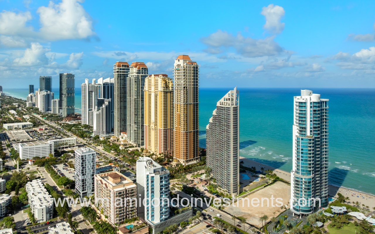 Aurora drone view of condo building from sky with buildings and ocean in background