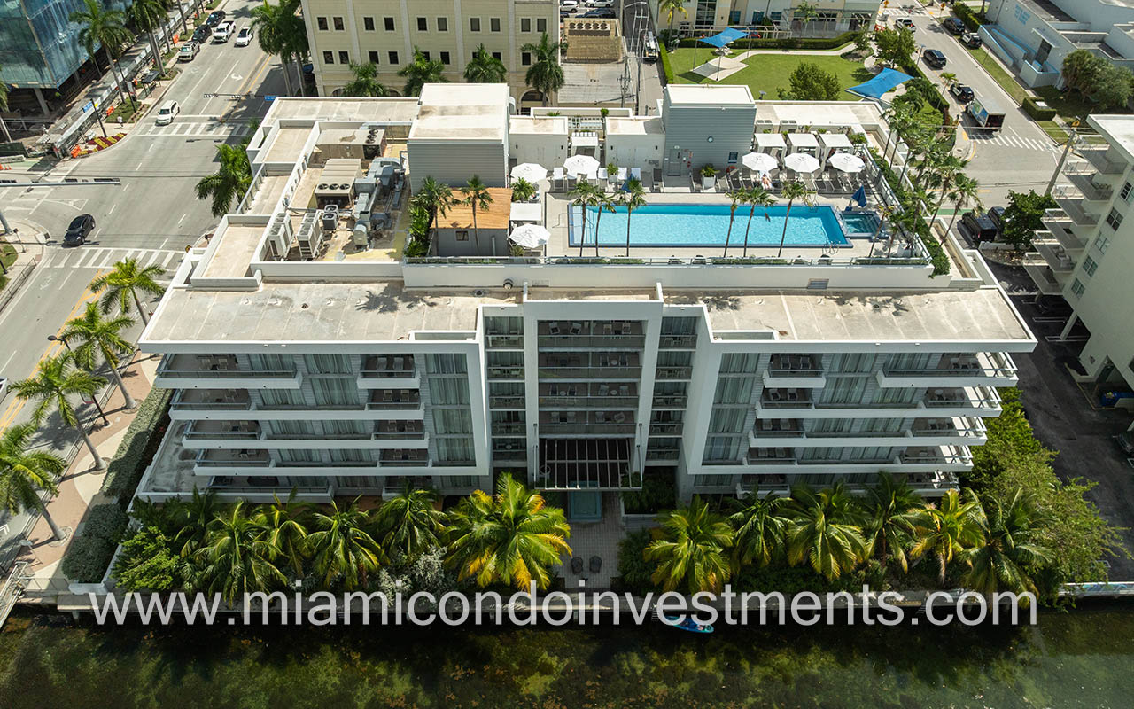 The Altair condo-hotel drone facing side of building with roof and pool