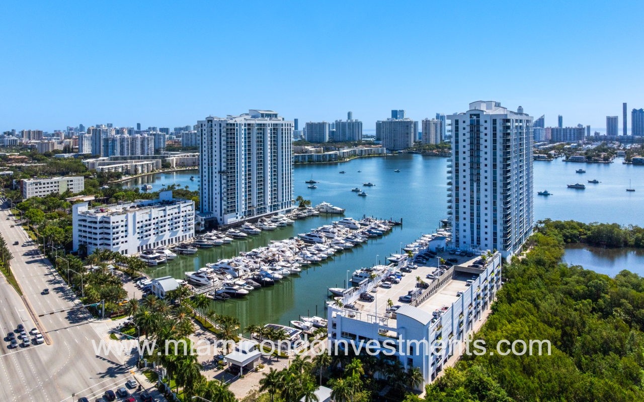 Marina Palms South drone angle view overlooking condo buildings and marina with buildings skyline